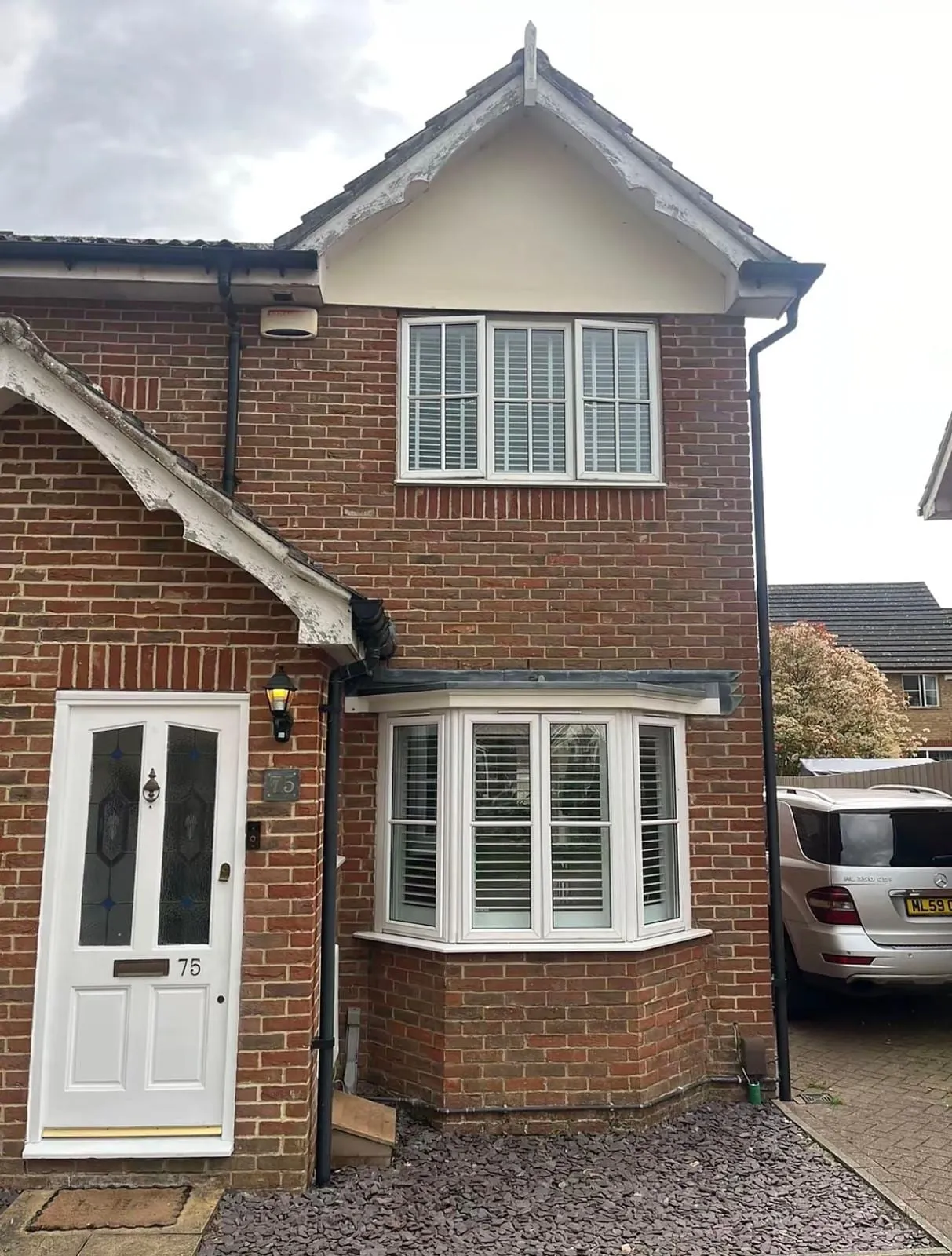 Brick house with white fascias, bargeboards and a bay window