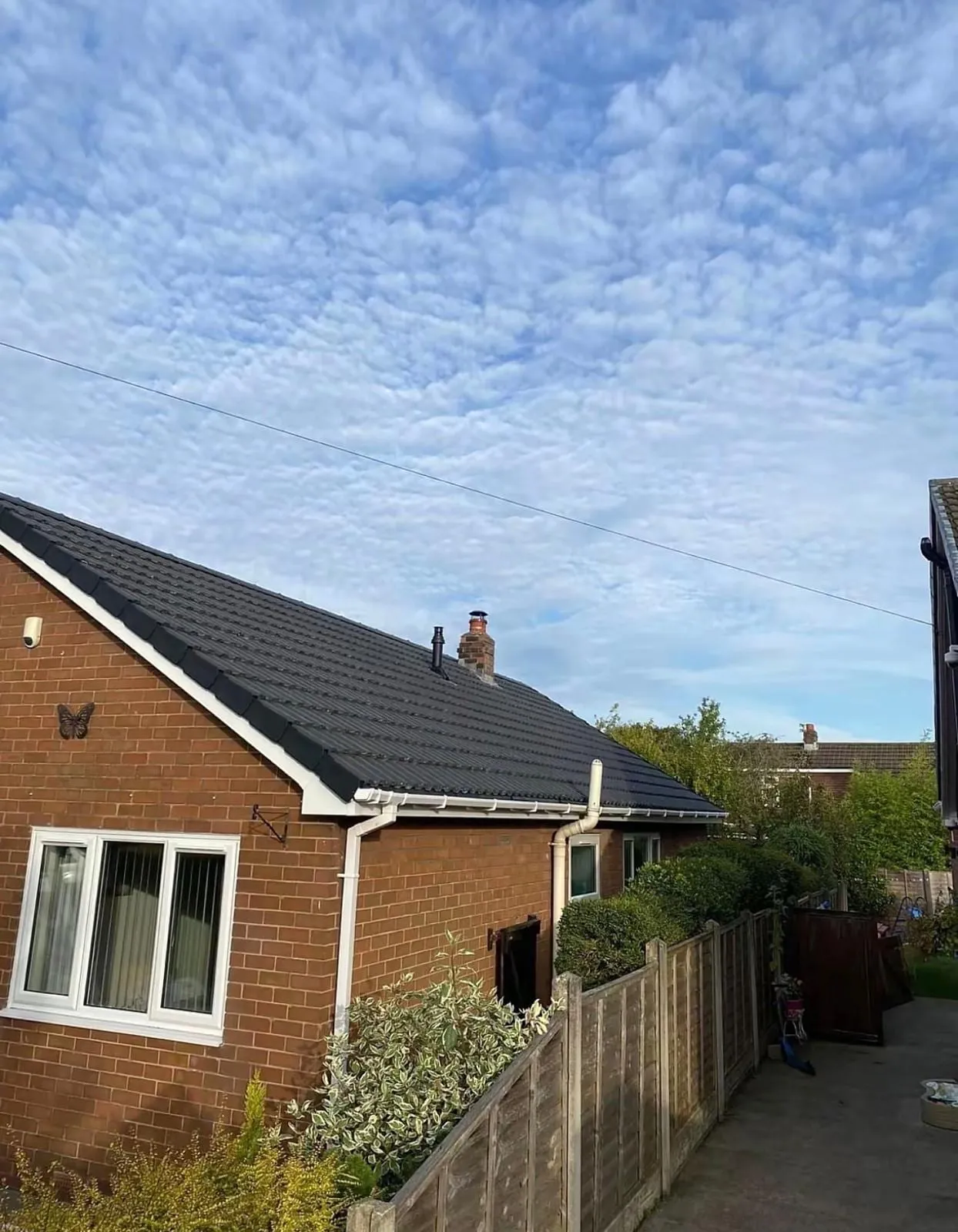 Bungalow with a new dark roof, white fascias and guttering