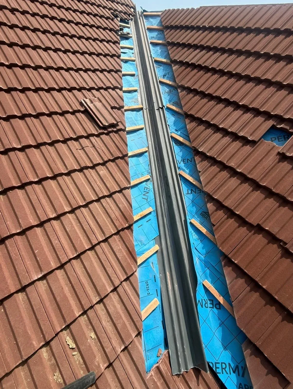 Lead valley laid over membrane between red tiles