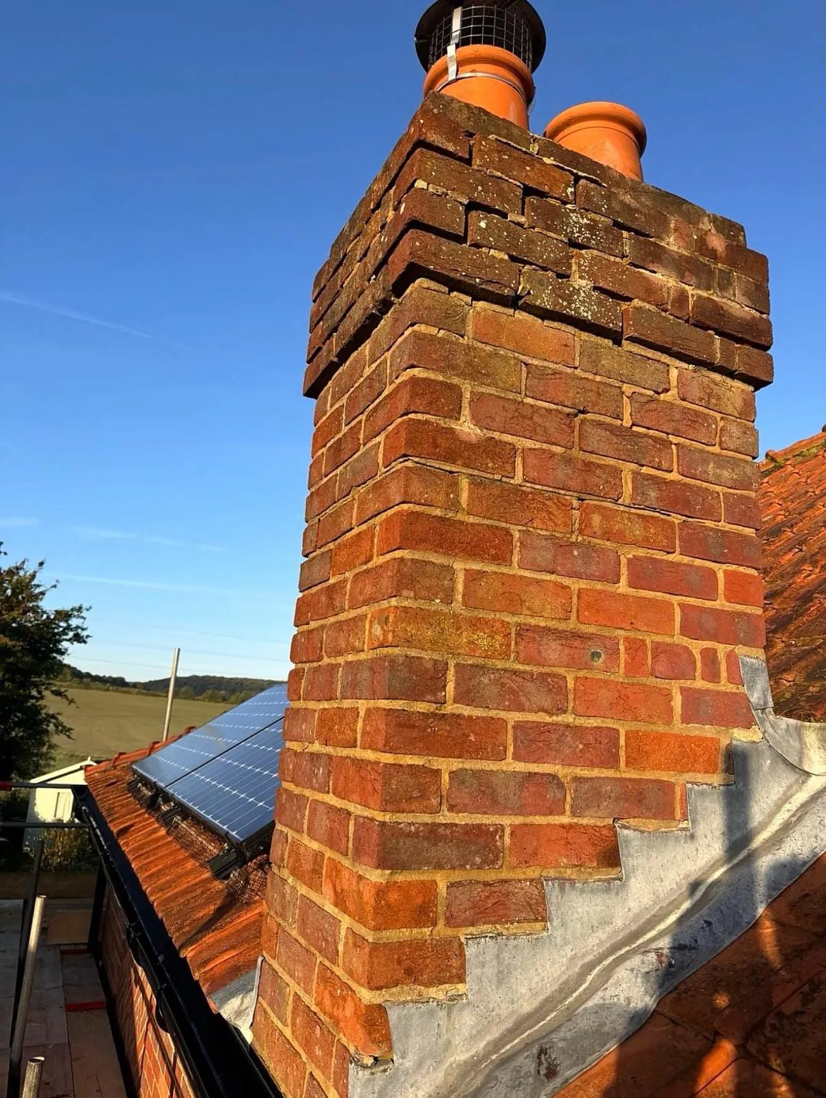 Tall brick chimney with two pots and stepped lead flashing