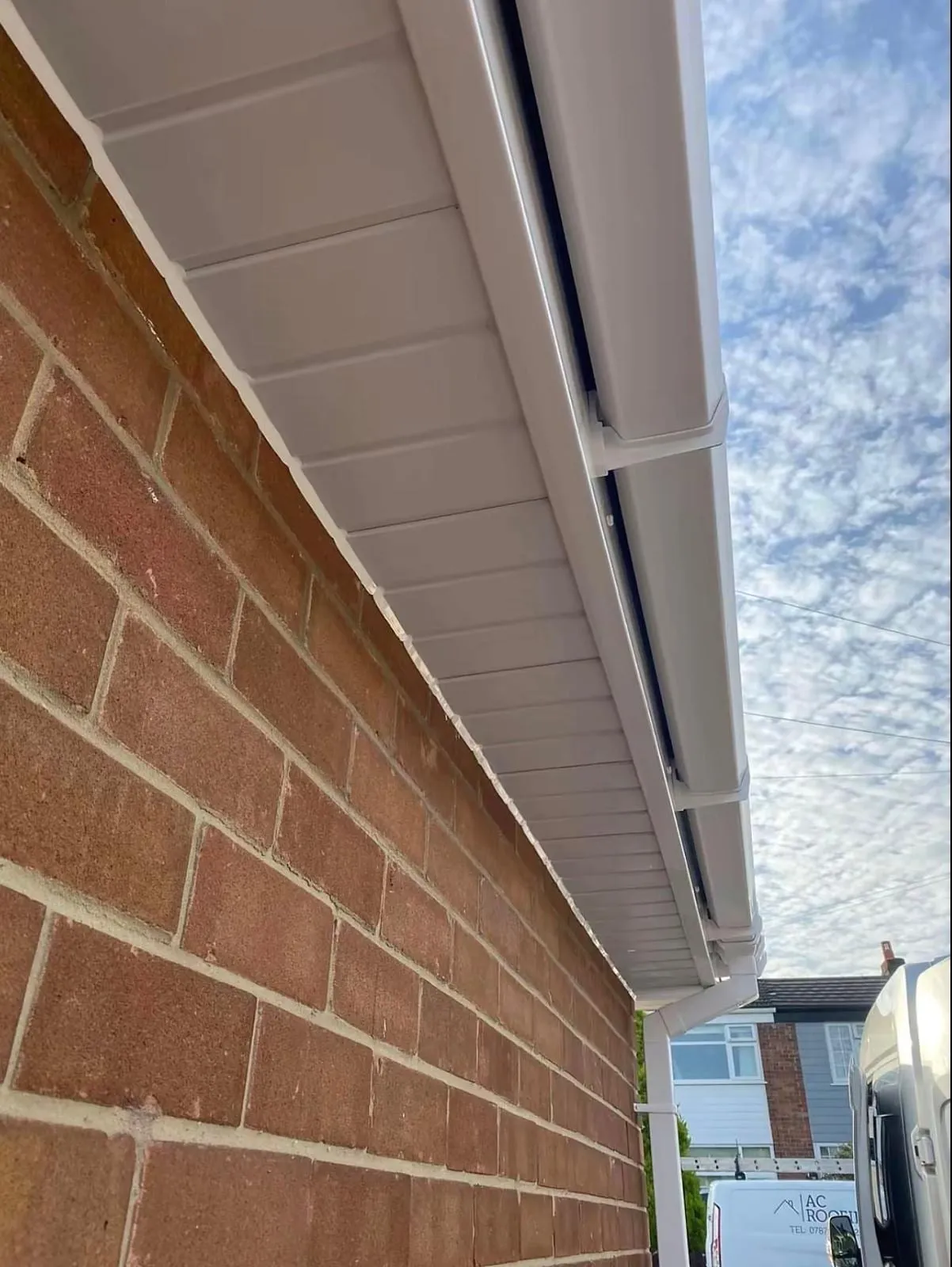 White fascia and soffit boards beside a brick wall